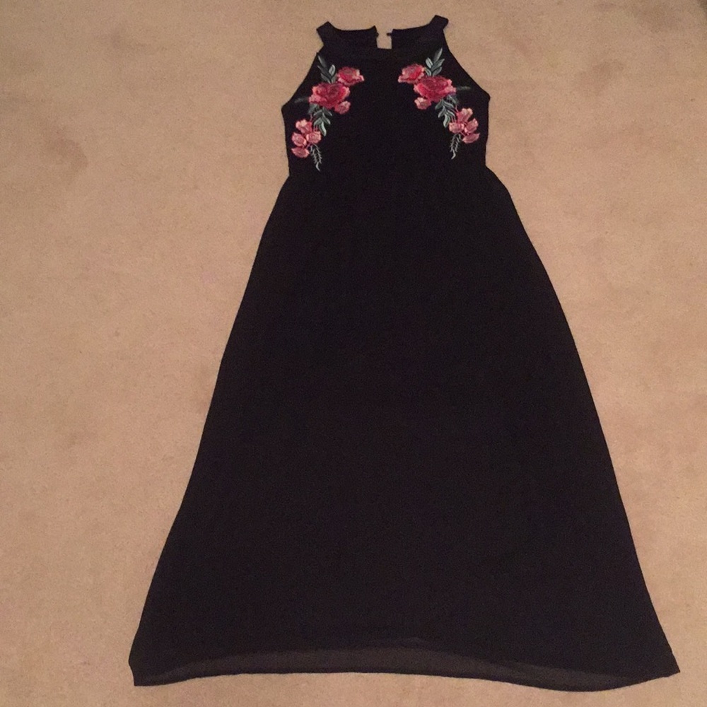 A girls black dress with pink flowers on the top.